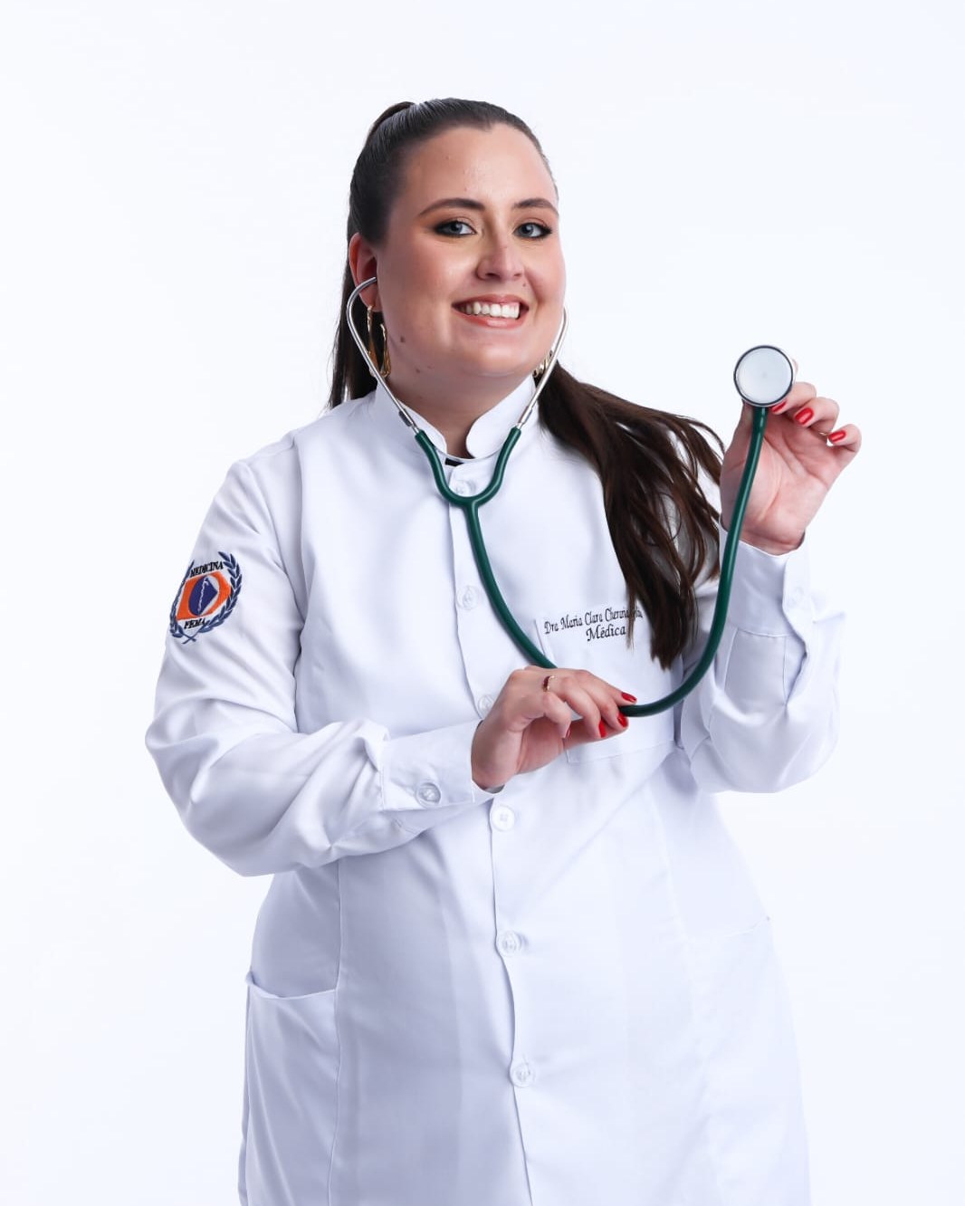 Dra. Maria Clara, de jaleco branco e estetoscópio, sorrindo para a câmera